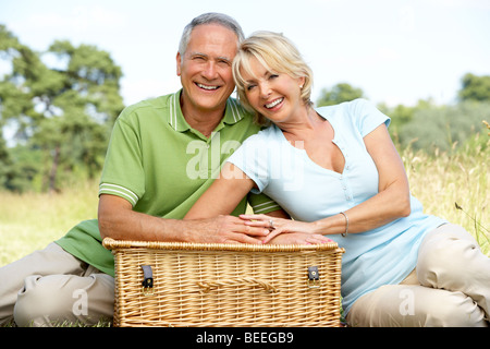 Coppia matura avente picnic in campagna Foto Stock
