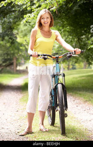 Donna Bicicletta Equitazione in campagna Foto Stock