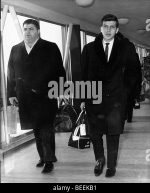 Il cantante Frank Sinatra Jr. in aeroporto con la sua guardia del corpo Foto Stock