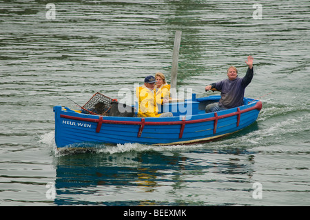 Tre 3 astice costiera pescatori tornando al porto in una piccola barca con le loro catture, Aberystwyth Wales UK Foto Stock