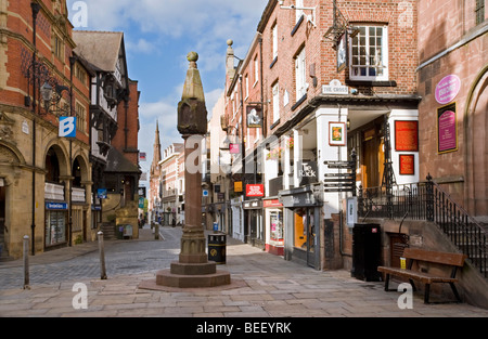 L'antica croce e le righe di Area dello Shopping in Bridge Street, Chester, Cheshire, Inghilterra, Regno Unito Foto Stock