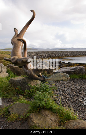 La lontra a caccia di un pesce, una scultura all'Ardmhor Ferry Terminal sul Isle of Barra, Ebridi Esterne, Scozia. Foto Stock