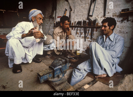 Gli uomini a gunshop, Darra, Pakistan. Foto Stock