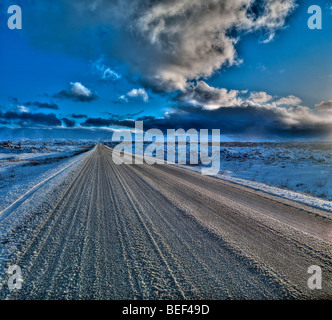 Coperta di neve road, lava e montagne, Hafnarfjordur, Islanda Foto Stock