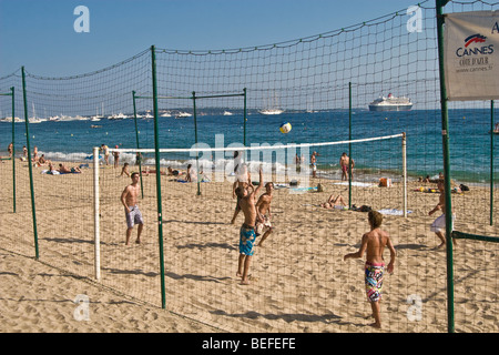 Ragazzi adolescenti a giocare a beach volley sulla spiaggia pubblica a Cannes, Francia Foto Stock