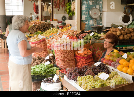 Persone che acquistano frutta e verdura presso il mercato coperto di Funchal, Madeira Foto Stock