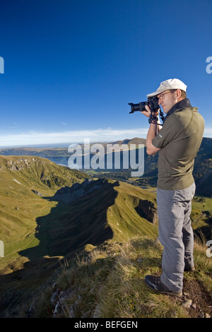 Un escursionista a fotografare il "Val de Courre' nel massiccio del Sancy (Puy de Dôme Francia). Randonneur photographiant Le Val de Courre. Foto Stock