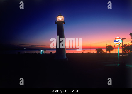 Il vecchio Biloxi Lighthouse sul Golfo del Messico in Mississippi con traffico passante al crepuscolo Foto Stock