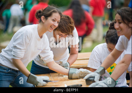 Volontario di Harvard Pilgrim Health Care partecipa in una città anno progetto per ristrutturare una parte interna della città di Boston scuola di charter. Foto Stock