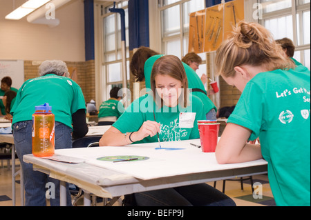 Volontario di Harvard Pilgrim Health Care partecipa in una città anno progetto per ristrutturare una parte interna della città di Boston scuola di charter. Foto Stock