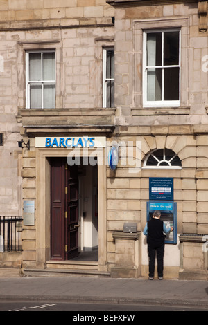 Alnwick, Northumberland, Inghilterra, Regno Unito. Barclays Bank con persona utilizzando il foro nella parete ATM Foto Stock