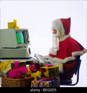 Babbo Natale digitando su una degli anni ottanta personal computer IBM, regali di Natale Foto Stock