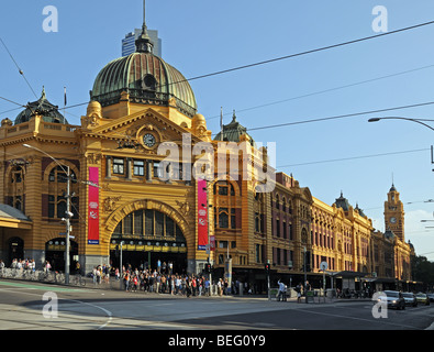 Ingresso principale alla stazione di Flinders e Flinders Street Melbourne Australia con la folla di persone sul marciapiede di traffico automobilistico Foto Stock