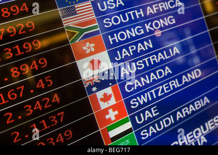 Rivenditore di denaro Travelex i tassi di scambio della valuta straniera visualizzato a Heathrow il Terminal 5. Foto Stock