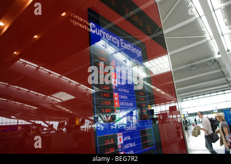 Rivenditore di denaro Travelex i tassi di scambio della valuta straniera visualizzato a Heathrow il Terminal 5. Foto Stock