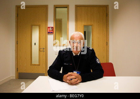 Un unnamed immigrazione Officer (IMO) con la UK Border Agency si siede in una detenzione doppia intervista all'aeroporto di Heathrow T5 Foto Stock