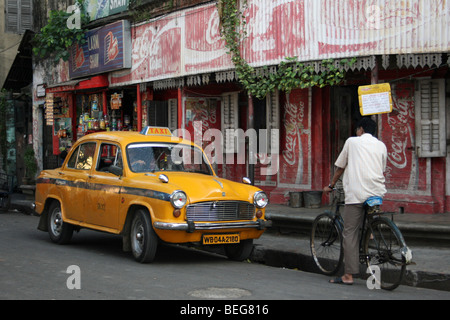 Tipica Indiana Street scene con Ambasciatore giallo Taxi Foto Stock