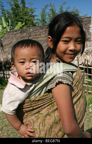 Konyak Naga tribù ragazza che trasportano i gemelli del Nagaland, India Foto Stock