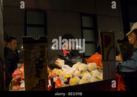 Una donna acquista il frutto da un frutto cinese peddler nella Chinatown di New York domenica 4 ottobre, 2009. (© Francesca M. Roberts) Foto Stock