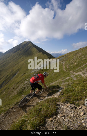 Un mountain biker cavalca un sentiero vicino a La Plagne nelle Alpi francesi. Foto Stock