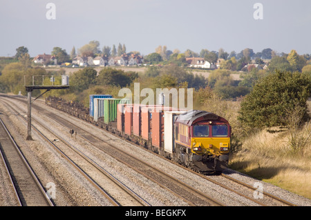 EWS/DBS Classe 66 locomotiva diesel n. 66141 con un trasporto intermodale delle merci a Cholsey nella valle del Tamigi. Foto Stock