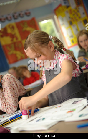 Una fase chiave due giovane ragazza che lavora in una classe di una piccola lingua gallese medie scuola primaria, Aberystwyth Wales UK Foto Stock