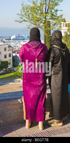 Due donne locali affacciato sul porto di Tangeri, Marocco Foto Stock