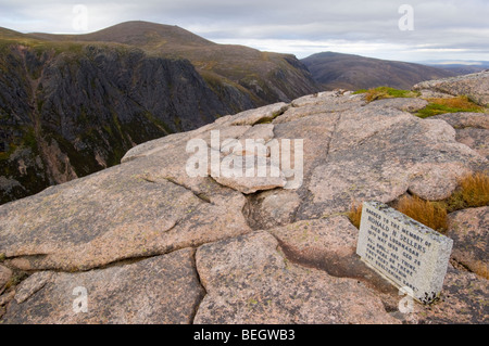 Monumento di pietra per un alpinista morto, situato su ghiacciate di roccia di granito in lastre in cima al Rifugio Rupe di pietra, Cairngorms Foto Stock