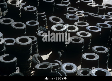 Pile di pneumatici usati in impianto di riciclaggio Foto Stock