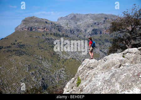 Escursionista femmina cercando in Torrent de Pareis con Puig Roig picco di montagna nella distanza Mallorca Spagna Spain Foto Stock