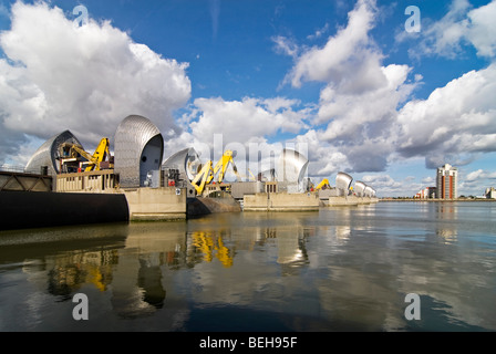 In orizzontale ampia angolazione del Thames Flood Barrier si riflette nel fiume, chiusa per lavori di manutenzione a Londra in una giornata di sole. Foto Stock