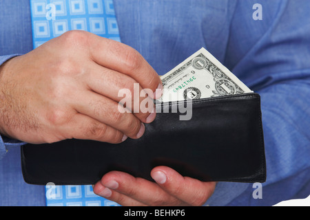Metà vista in sezione di un imprenditore tenendo un dollaro al di fuori del suo portafoglio Foto Stock
