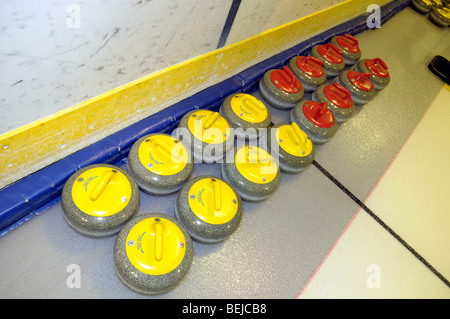 Giallo e Rosso pietre di Curling su ghiaccio. Foto Stock