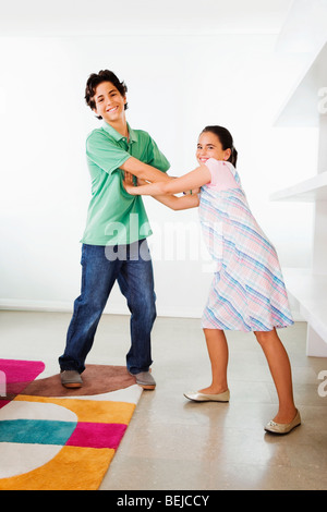Ragazzo avente un gioco di combattimenti con sua sorella Foto Stock