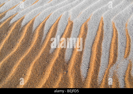 Modello di ondulazioni di sabbia e di ghiaccio sulla spiaggia durante il gelo in inverno Foto Stock