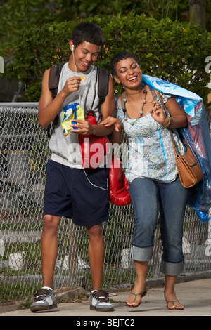 Ragazzo adolescente e sua sorella camminando sul marciapiede Foto Stock