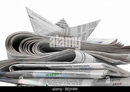 Ein Stapel Zeitungen mit Schiff aus Zeitungspapier Foto Stock