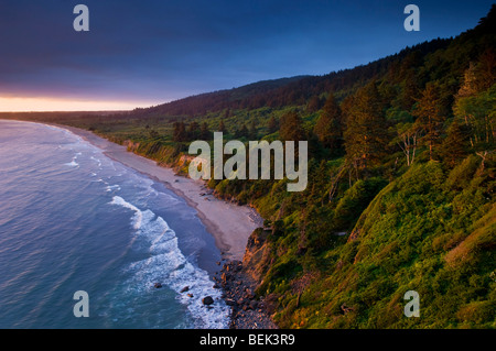 La luce del tramonto e nuvole sopra le colline sopra Enderts Beach, vicino a Crescent City, il Parco Nazionale di Redwood in California Foto Stock