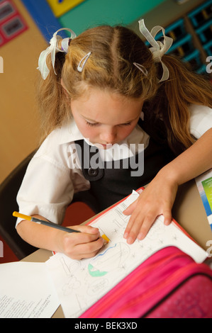 Una fase chiave due giovane ragazza che lavora in una classe di una piccola lingua gallese medie scuola primaria, Aberystwyth Wales UK Foto Stock