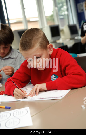 Una fase chiave due giovane ragazzo lavora in una classe di una piccola lingua gallese medie scuola primaria, Aberystwyth Wales UK Foto Stock