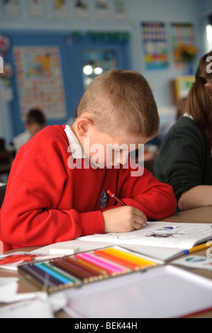 Una fase chiave due giovane ragazzo lavora in una classe di una piccola lingua gallese medie scuola primaria, Aberystwyth Wales UK Foto Stock