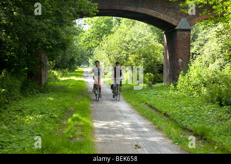 Due ciclisti in bicicletta lungo la vecchia ferrovia il Groene 62, tra Torhout e Ostenda, Belgio Foto Stock