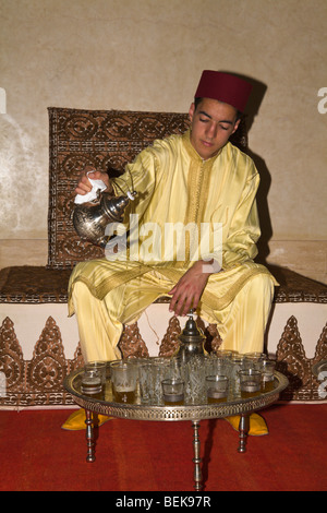 Cameriere a hotel in abito tradizionale versando il tè alla menta essaouira marocco Foto Stock