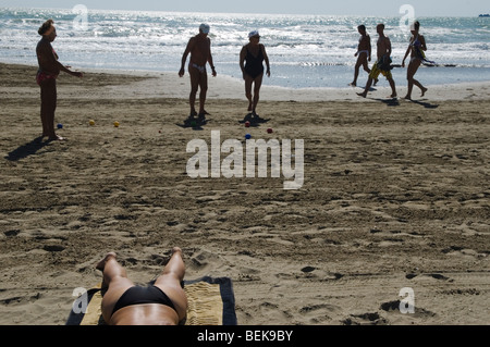 Gli italiani giocano a boule, la spiaggia al Lido di Venezia. Donna in bikini e vacanziere che passa accanto. Mare Adriatico Italia anni '2009 2000 HOMER SYKES Foto Stock