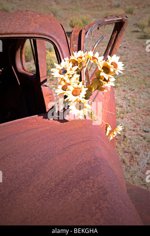 Una vecchia ruggine auto sconosciuto di marca e modello si siede la formazione di ruggine sulle colline di miniere d'oro città fantasma di Elizabethtown, NM Foto Stock