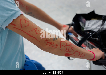 Un close-up dettaglio di adolescenti parole scritte in pennarello sulla giovane un braccio nell'atrio partenze di Heathrow. Foto Stock