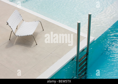 Sedia a bordo della piscina vicino a scaletta Foto Stock