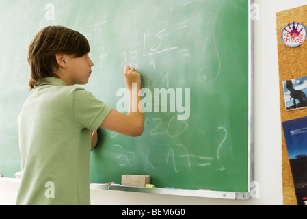 Ragazzo iscritto con il gesso sulla lavagna Foto Stock