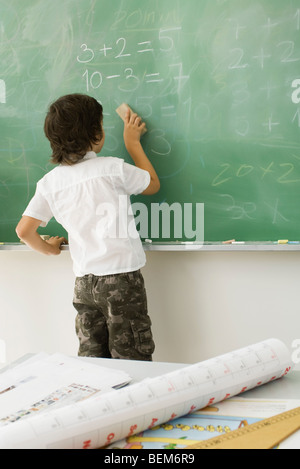 Ragazzo la cancellazione di lavagna, vista posteriore Foto Stock