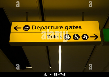 Segno per i cancelli di partenza e per i servizi igienici, nella sala partenze del Terminal Sud, Aeroporto di Gatwick. Londra. Regno Unito. Foto Stock